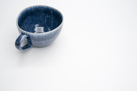 A ceramic blue tea cup isolated on a white background with free space for textの写真素材