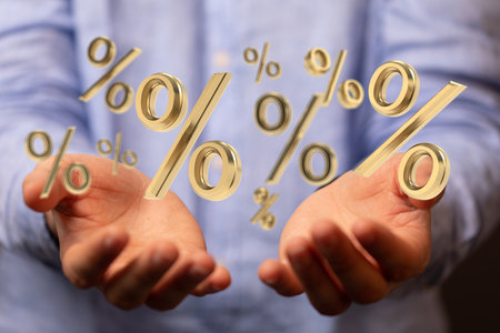 A hand holding 3D percent signs in the airの写真素材