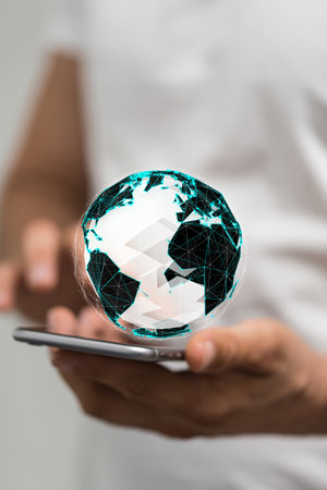 A closeup of a 3D rendered globe hologram hovering over a phone in man's hand - network and communication conceptの写真素材