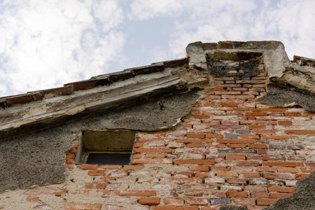 A closeup shot of a brick wall and a roof on a cloudy sky backgroundの写真素材