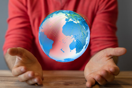 A male's hand holding the illustration of the Earthの写真素材