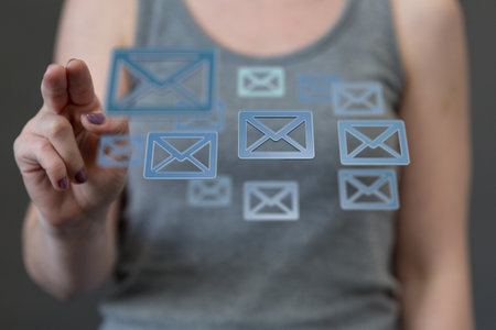 A digital concept of online people network, using the internet for communication, finger pointed at floating email iconsの写真素材
