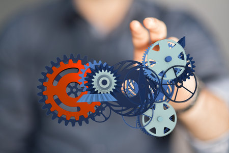 A male's hand pointing to a gear technology setting concept backgroundの写真素材