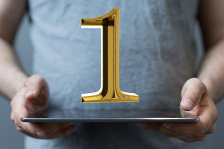 A digital 3d gold  number 1 logotype for the anniversary or fits place trophy, floating out of a tabletの写真素材