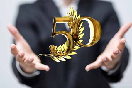 A digital 50 years anniversary award in a handの写真素材