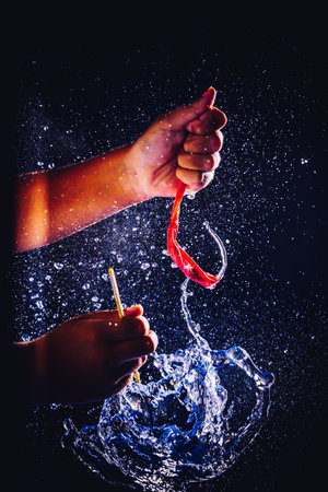 A closeup shot of hands and waterdrops on dark background