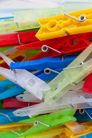 A closeup of a heap of colorful plastic laundry clothespinsの写真素材