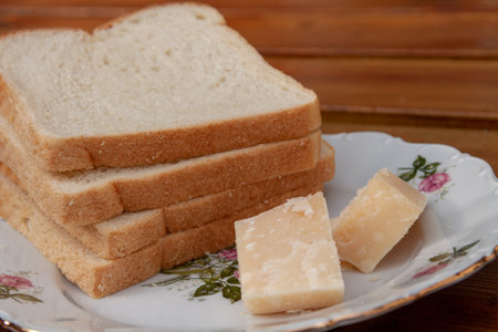 A closeup of slices of fresh white bread with cheese on a plateの写真素材