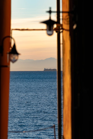 A vertical shot of the blue sea as seen between two buildingsの写真素材