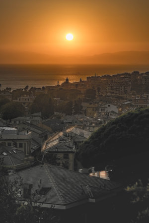 A vertical shot of a golden sunset over a coastal cityの写真素材