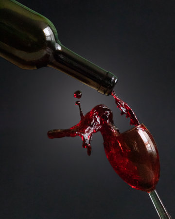 The process of filling a glass with a red wineの写真素材