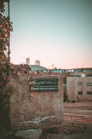 A vertical shot of street signs on ruined building walls under the sunlight in Jordanの写真素材