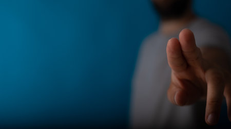 A man pressing on a touch screen on a blue backgroundの写真素材