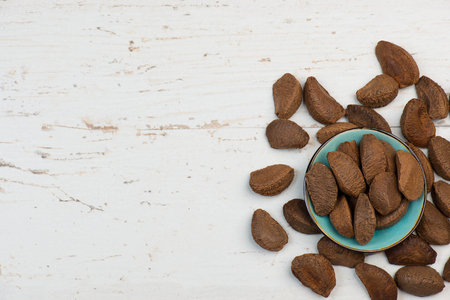 Pecan nuts on a textured shabby white background, healthy vegan food