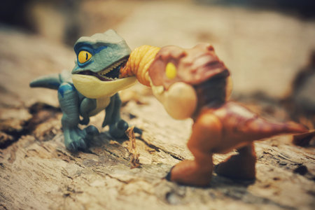 A closeup of two small figurines of dinosaurs with the blurred backgroundの写真素材