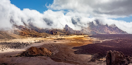 A beautiful view of the clouds over the cliff and a person walking near itの写真素材