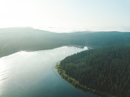 Picture of a drone flight over a blue lake at sunrise.の写真素材
