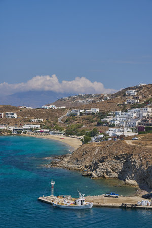 A vertical shot of a blue ocean surrounded by hills with residential housesの写真素材
