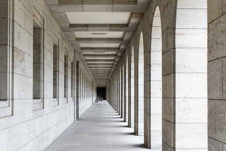 In an arcade of columns and windows, there are bicycles and a bike rack at the end.の写真素材