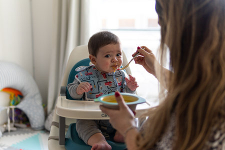 The Hispanic mother feeds the babyの写真素材