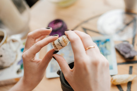A closeup shot of a Caucasian female hands with a small capsule with herbs in an art studioの写真素材