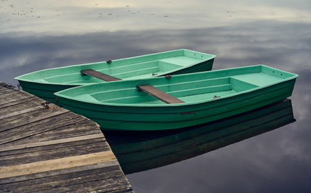 A lake with the trees in the background and a boatの写真素材