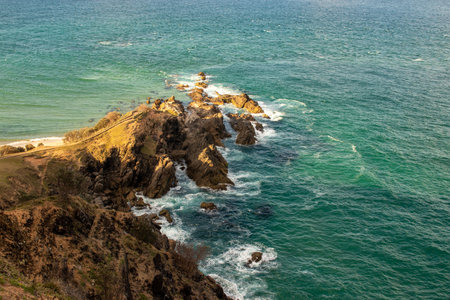 Yellow sun over rocks, Byron Bay coastline. New South Wales, Australia