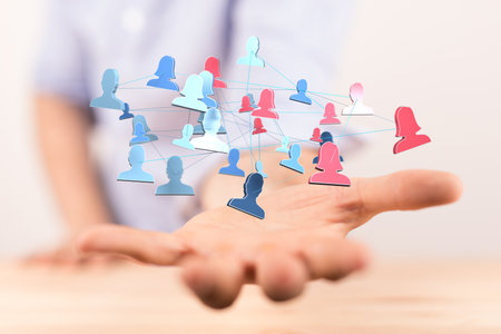 A 3D rendered hologram of interconnected people on a man's palm - global networking and connection conceptの写真素材