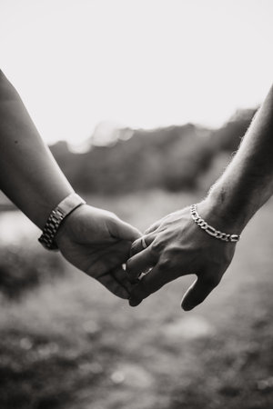 A vertical grayscale shot of a loving couple's hands, outdoorsの写真素材