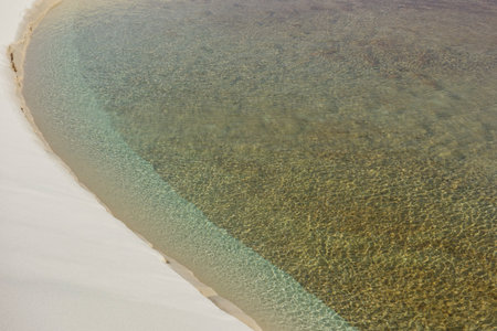 A beautiful shot of white sand dunes and clear lagoon in Lencois Maranhenses National park in Brazilの写真素材