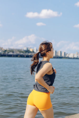 A young East Asian female doing her early morning jogging and workout outdoors, South Korea