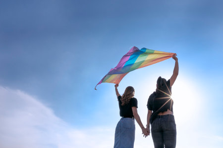 A back view of 2 females with LGBT flagの写真素材