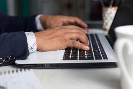 A young man in a suit working on a laptop or studyingの写真素材