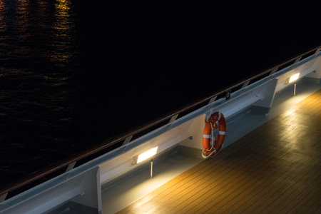 The lit deck of a boat with an emergency lifebuoyの写真素材