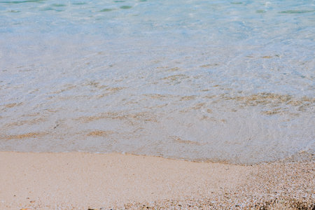 A high angle shot of waves washing a sandy shore