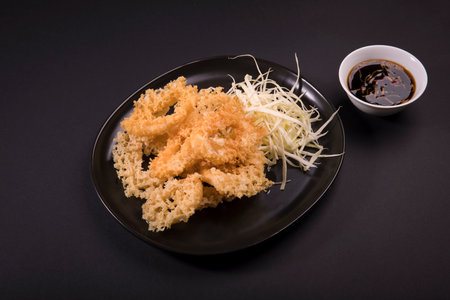 A top view of fried shrimps served with cheese and soy sauce on a black backgroundの写真素材