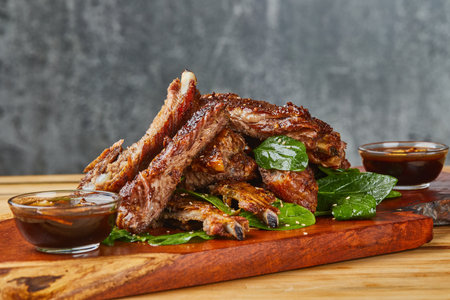 A closeup shot of delicious ribs on a wooden boardの写真素材