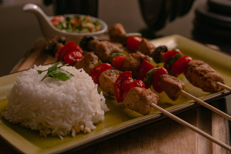 A closeup of delicious Paneer tikka with rice on a track on the table in a restaurantの写真素材