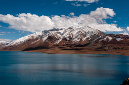 A landscape with blue water and snowy mountains on the horizonの写真素材