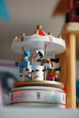 A closeup of a white musical carousel toy with horses in children's roomの写真素材