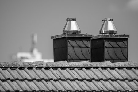 A selective focus of two vents on a roof in grayscaleの写真素材