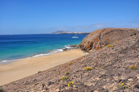 View over coastal landscape and beach on Spanish volcanic canary island Lanzaroteの写真素材