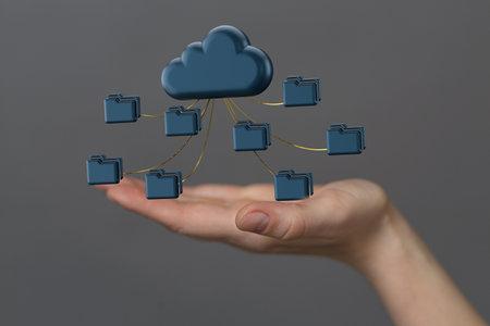 A 3d rendering of computer folders connecting to a single data cloud in hand on a gray backgroundの写真素材