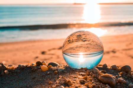 A beautiful shot of a water drop reflecting the sea and the sunsetの写真素材