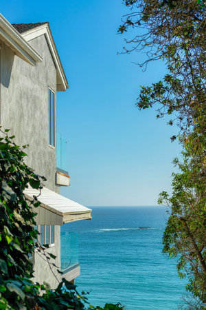 A vertical shot of sea view with a building and trees in the foreground