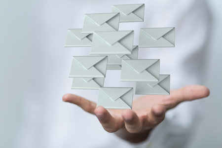 A 3D rendering of emails in a hand; electronic communication conceptの写真素材