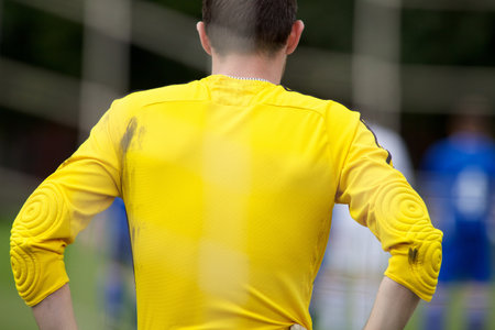 A rear shot of a malegoalkeeper in yellow clothingの写真素材