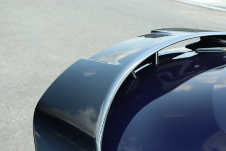 A rear view of a modern black sports car parked outdoors on a sunny daの写真素材