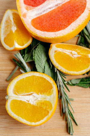 A vertical shot of sliced oranges and a grapefruit on a wooden tableの写真素材