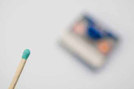 A selective focus of a green match isolated on a white backgroundの写真素材